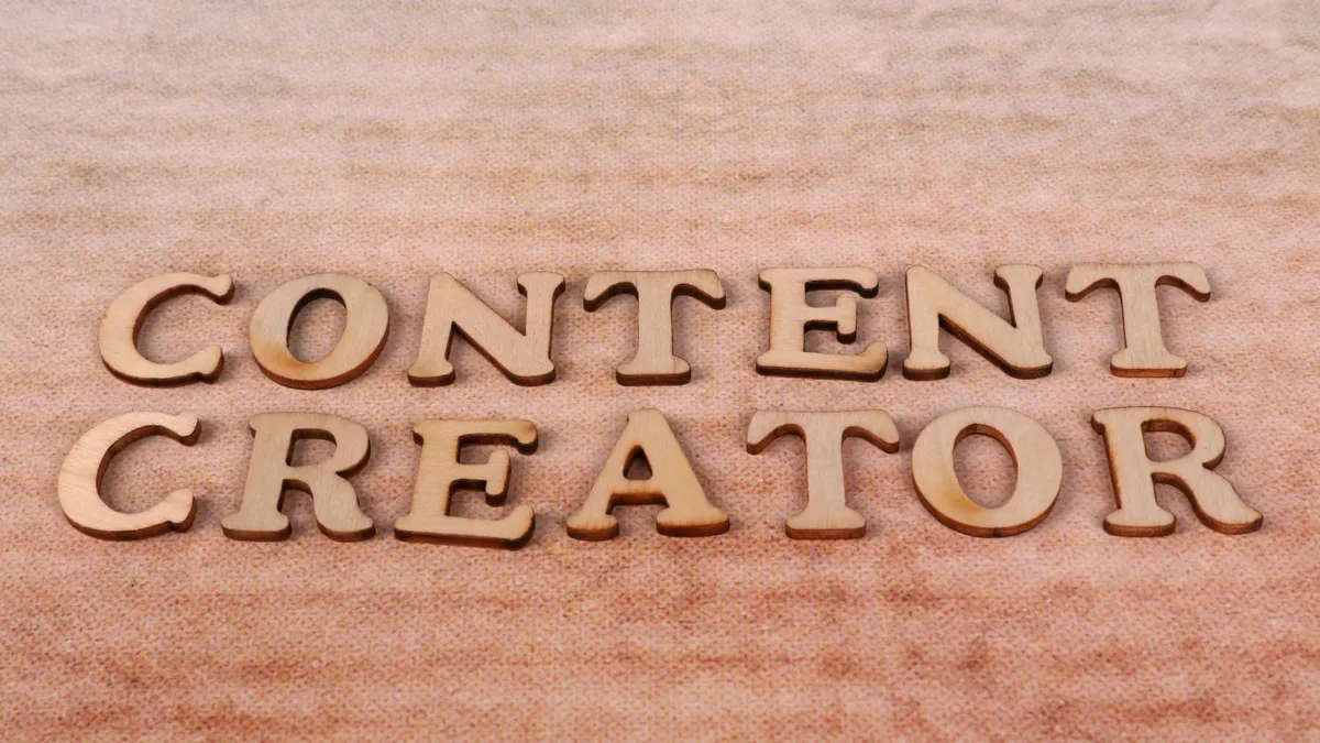 Content writing agency vs content writing service: what's the difference? — Wooden Lettering 'Content Creator' on Textil