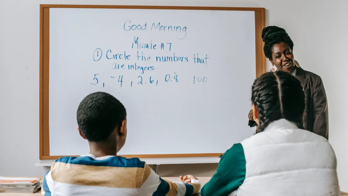 Content writing service packages explained — Content black teacher explaining new material to diverse schoolchildren