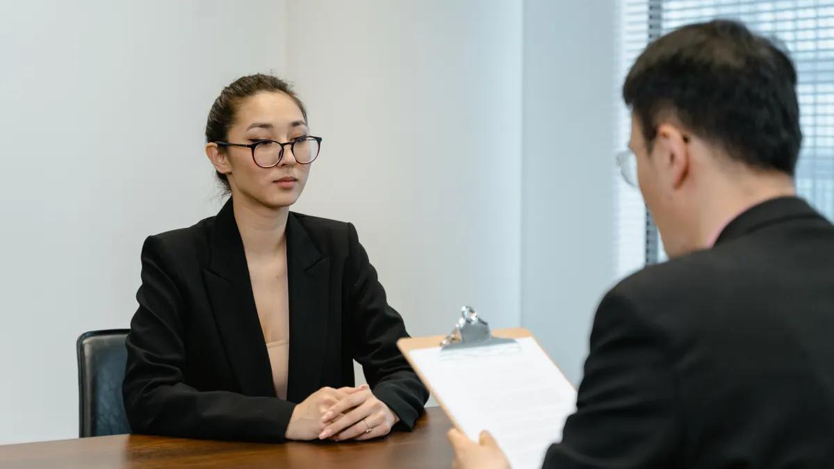 job interview across a desk with clipboard