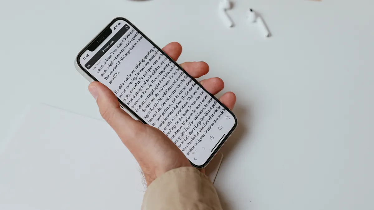 How much do content writers cost? — A Person Writing While Holding a Smartphone