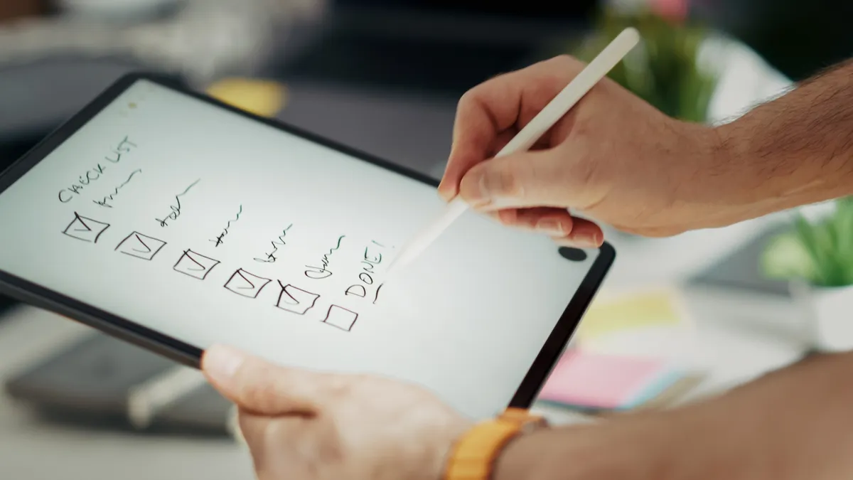 How to brief a content writer for SEO, thought leadership, and landing pages hand using stylus on a checklist on a tablet