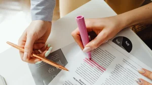 Hands highlighting and marking up a printed document