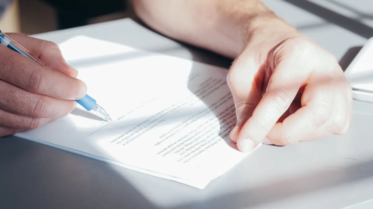 Hands marking up a document with a pen