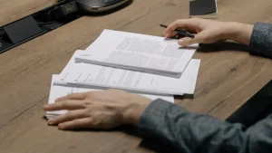 Hands reviewing printed pages on a desk