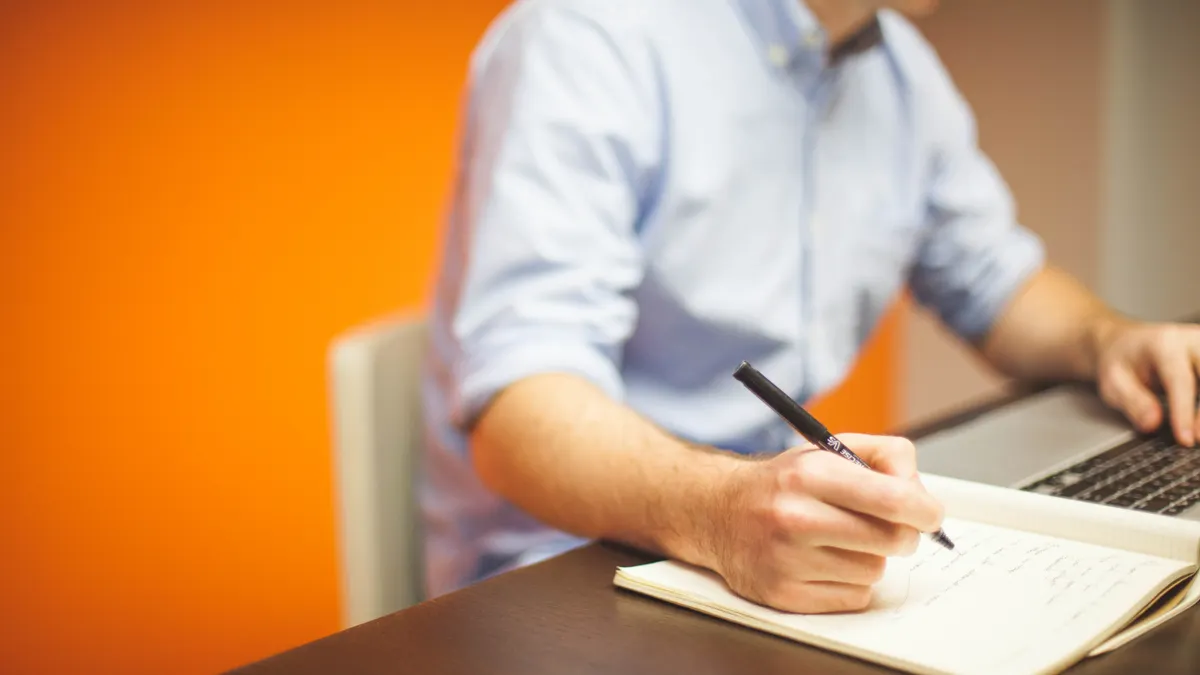 How to write a content writer job description — Focus Photography of Person Writing on Desk Using Laptop