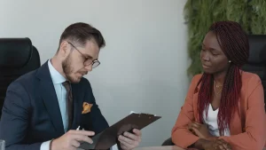 Hiring interview with a candidate and interviewer reviewing a clipboard