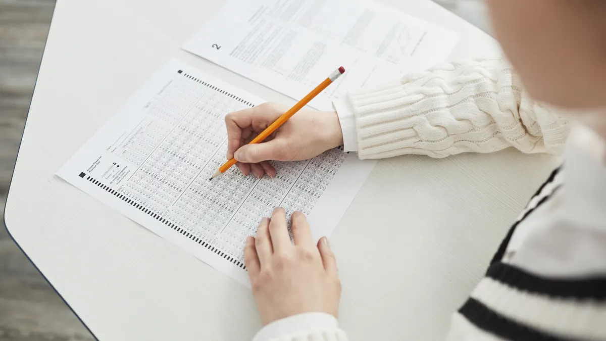 Person answering a test sheet at a desk