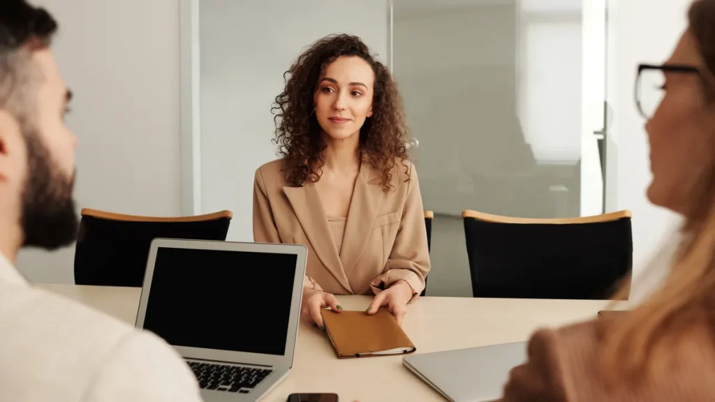 job interview around a table with laptop and clipboard